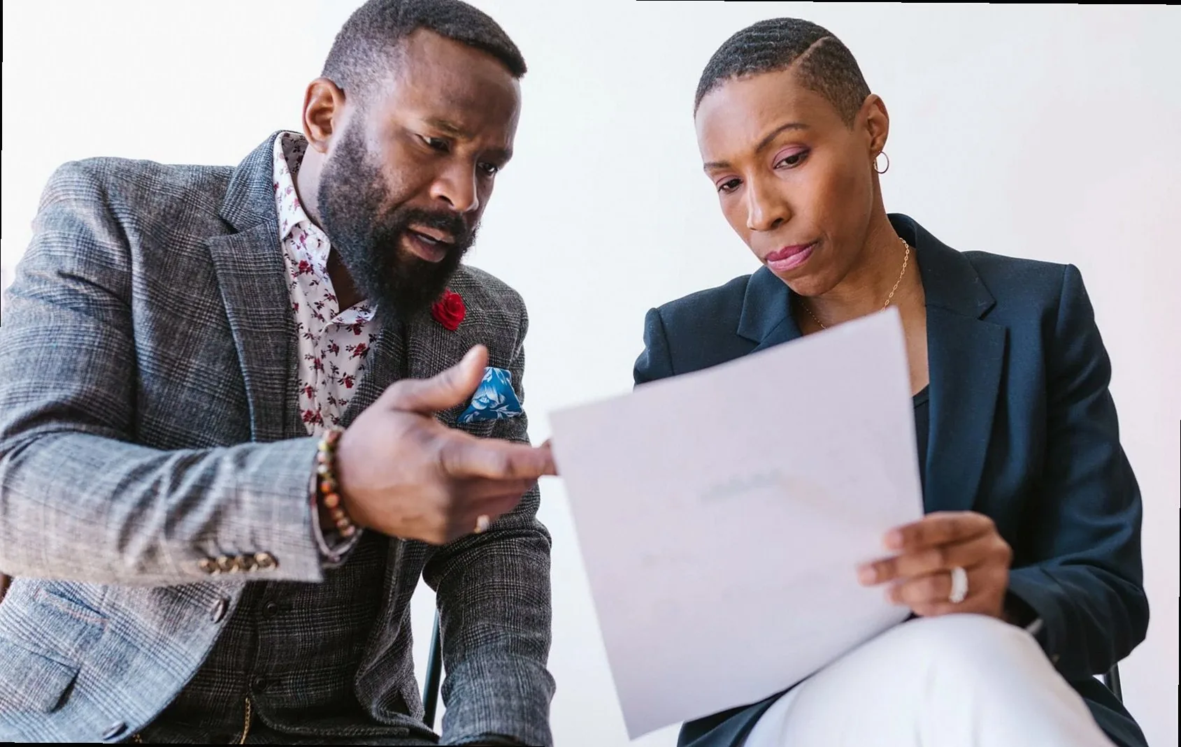 Two business professionals reviewing a document together in an office setting.